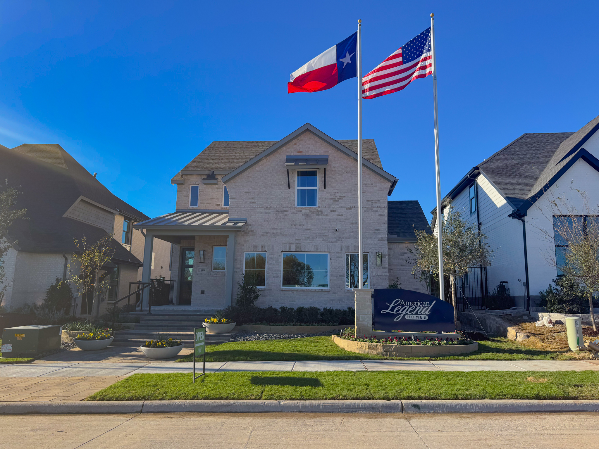 American Legend Homes model home at Hillstead community in Lavon TX with Texas and US flags