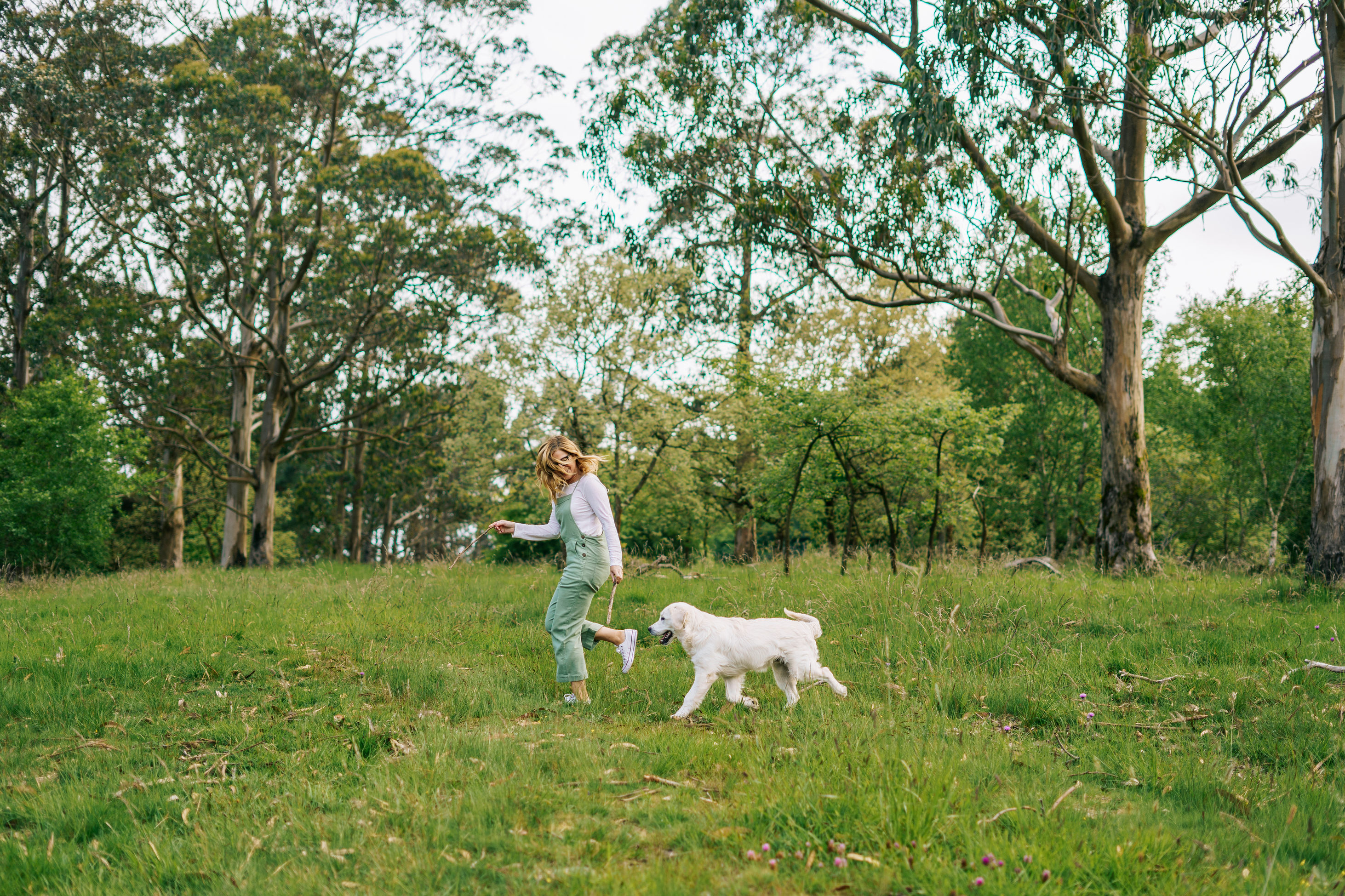 Woman playing with dog in open green park near Lavon TX community trails